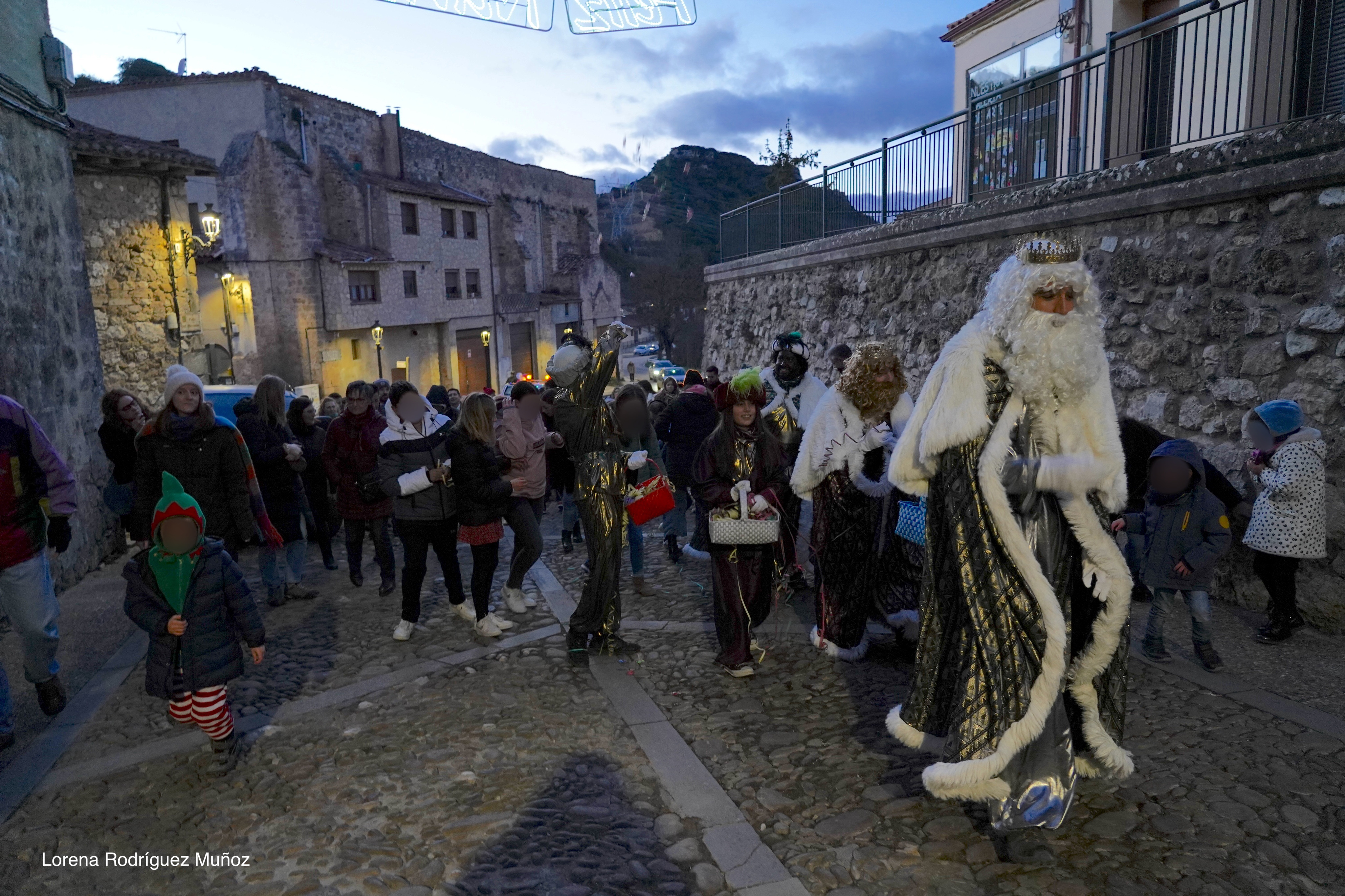 Fotografía de los Reyes Magos junto a las familias subiendo por la calle principal de Frías.
